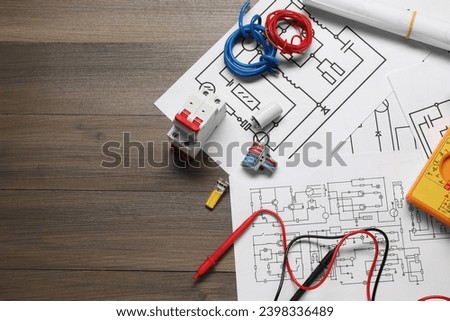 Flat lay composition with wiring diagrams on wooden table, space for text