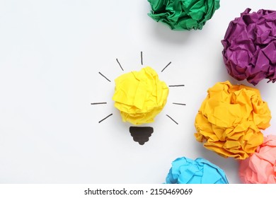 Flat lay composition with yellow crumpled paper ball as lamp bulb on white background, space for text. Idea concept