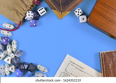 Flat Lay Concept Design For Tabletop Role Playing With Blue And White RPG Dices, Character Sheet And Rule Books With Empty Copy Space On Blue Background