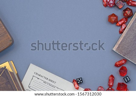 Flat lay concept design for tabletop role playing with cred RPG dices, character sheet and rule books with empty copy space on gray background