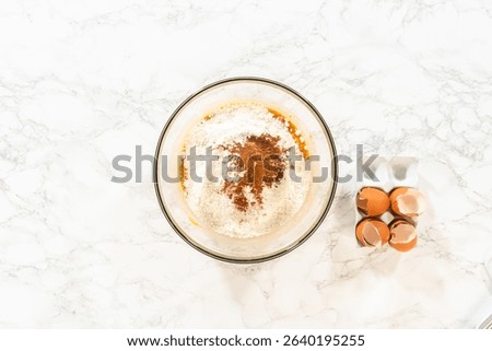 Flat lay. In a cozy kitchen, a large mixing bowl becomes the stage for expertly blending the ingredients, setting the scene for crafting a delightful homemade pumpkin bundt cake from cake mix.