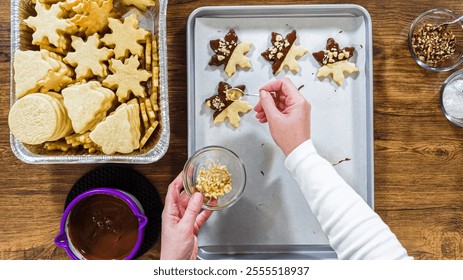 Flat lay. Creating snowflake-shaped cutout sugar cookies, dipped in chocolate, and adorned with different toppings. - Powered by Shutterstock