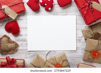 Flat lay cute composition with handmade fabric heart. White paper and retro mail envelopes on wooden table. Happy birthday or anniversary congratulation. Romantic message template with copy space