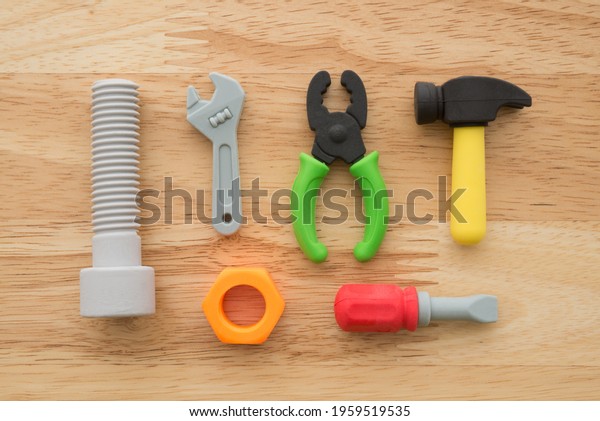 Flat lay of cute\
repair, construction tools equipment eraser toy set on wooden\
background minimal style. Construction, repair, maintenance or DIY\
concept display in cute kids\
toy.