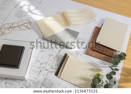 Flat lay design of creative interior design moodboard composition with samples materials like wood, textile, stone and black switch on blueprint background