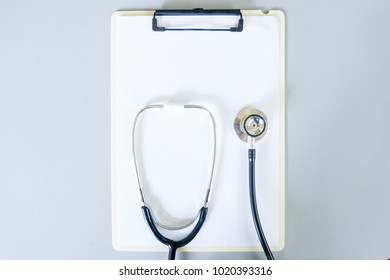 Flat Lay Design Of Stethoscope And Blank Clipboard Pad With For Medical Concept. Top View.