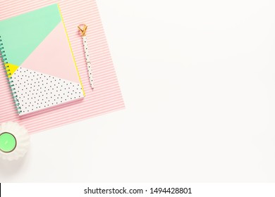 Flat lay desk table. Workspace with modern notebook and a pen on white table. Copy space, top view. Feminine concept
