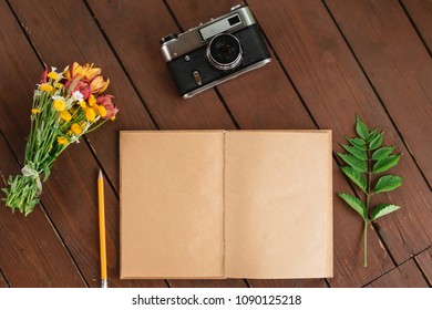 flat lay diary. Top view of notebook paper and camera on a wooden background.