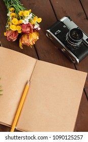 flat lay diary. Top view of notebook paper and camera on a wooden background.
