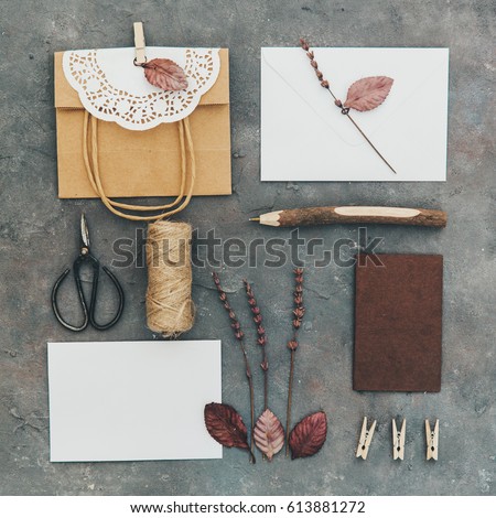 Flat lay of different object on vintage background. Craft brown bag, empty blank and tools. DIY concept. Homemade invitation card. Rustic style for wedding 