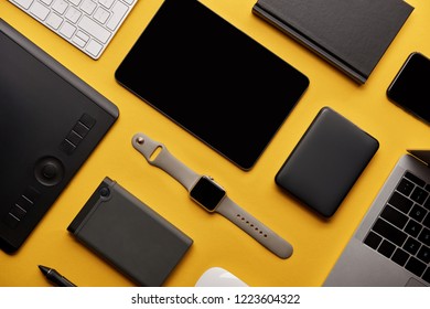 flat lay with different wireless devices on yellow surface