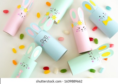 Flat lay with diy paper Easter bunnies and colorful candies, easy crafts for kids.          