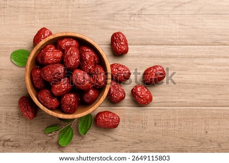 flat lay of dried red date in wooden bowl.