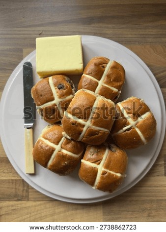 Flat Lay Of Easter Hot Cross Buns On Plate With Butter Block And Knife Against Wooden Worktop With text Space Portrait Composition