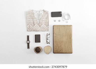 Flat lay of everyday essentials including watch, wallet, phone, glasses, and traditional fabric on white background. Minimal lifestyle arrangement with clean copy space.
