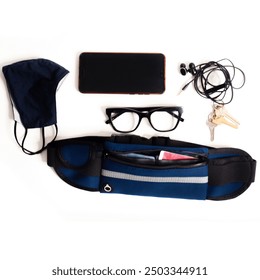 Flat Lay of Everyday Essentials: Mask, Phone, Glasses, Earphones, Keys, and Waist Bag on White Background - Powered by Shutterstock