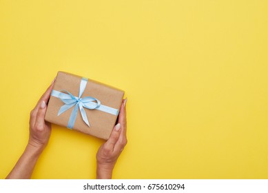 Flat lay of fantastic wrapped present decorated with bow on yellow background - Shutterstock ID 675610294