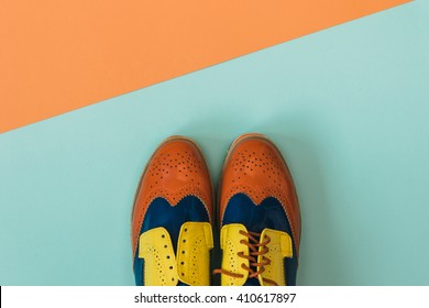 Flat lay fashion set: colored vintage shoes on colored background. Top view. 