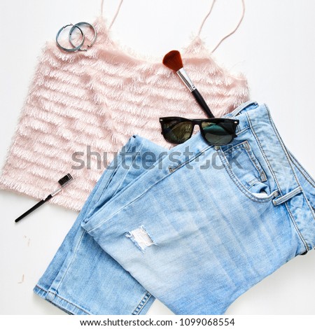 flat lay feminine clothes and accessories collage with jean, sunglasses, earring White wood table background