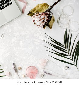 flat lay feminine home office workspace with laptop, proteus flower, necklace, palm branches and accessories. top view – Ảnh có sẵn