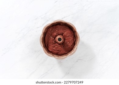 Flat lay. Filling metal bundt cake pan with cake butter to bake red velvet bundt cake with cream cheese glaze - Shutterstock ID 2279707249