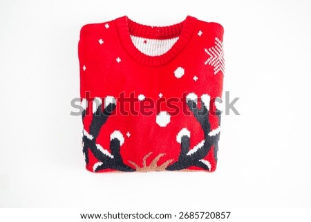 Flat lay folded red knitted christmas sweater on white background. Knitted winter pullover top view empty copy space. Holiday decoration. Seasonal clothes.