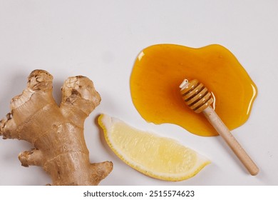 A flat lay of fresh ginger root, a slice of lemon, and honey drizzled on a white surface. A small wooden honey dipper rests in the honey, creating a natural and healthy food composition. - Powered by Shutterstock