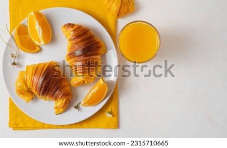 flat lay with Freshly baked portuguese Brioche croissants on a plate with orange juice and chocolate milk. Tipical portuguese breackfast