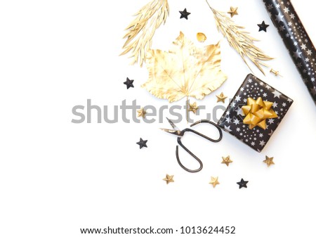 Flat Lay with Gift box and Wrapping Paper in Gold and Black tones. Isolated on white. Party preparation