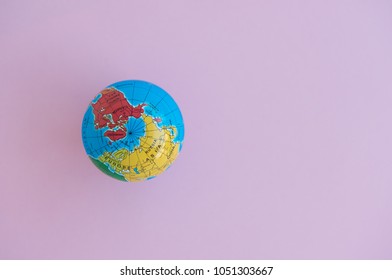 Flat lay of globe model on the pink background