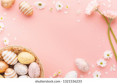 Flat Lay of Golden Easter Eggs Pattern with small flowers and petals on pink background. Easter background or easter concept. Square. 