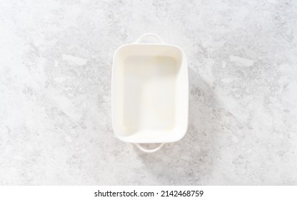 Flat Lay. Greasing White Casserole Dish To Bake Bread Pudding.