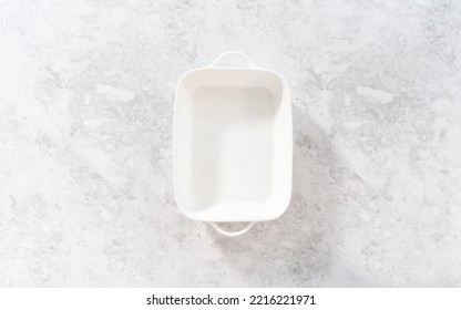 Flat Lay. Greasing White Casserole Dish To Bake Bread Pudding.