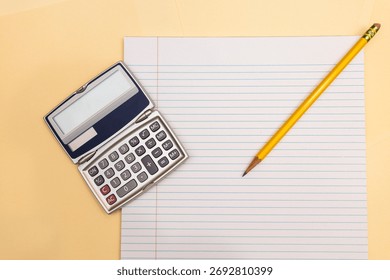 flat lay of a handheld calculator and a sharpened pencil on notebook paper against manila folders