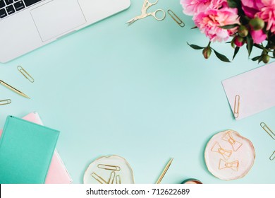 Flat Lay Home Office Desk. Female Workspace With Laptop, Pink Peonies Bouquet, Golden Accessories, Pink And Mint Diary On Mint Background. Top View Feminine Background.