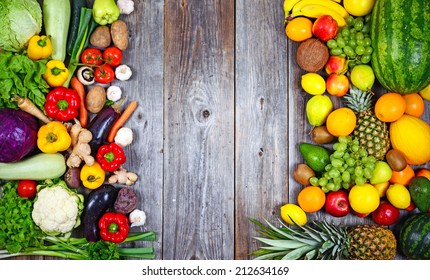 Flat lay of huge group of fresh vegetables and fruit on wooden background - Vegetables VS Fruit - High quality studio shot -  Flat lay - Powered by Shutterstock