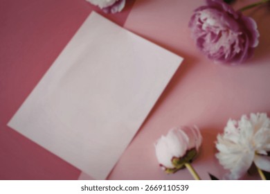 A flat lay image featuring a blank pale pink notecard surrounded by pink and white peonies on a pink background. The scene is minimalist and elegant.