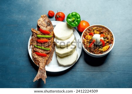 flat lay image of fried fish with ingredients and a sliced of yam arranged on a plate, sauce in a bowl- food concept 