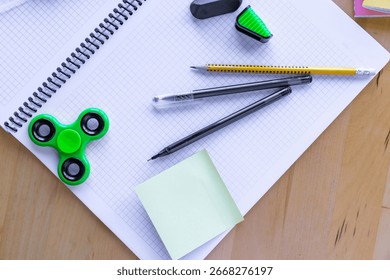 Flat lay image of an open squared grid notebook placed on a blue background next to a black gel pen, a mechanical pencil, and sticky notes. Bright natural lighting and clean composition create a