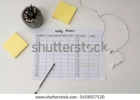 Flat lay image of weekly planner with stationary scattered around. Revision timetable for exams or activity planner.