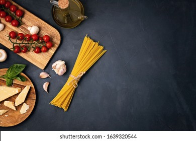 Flat lay of Ingredients for cooking italian pasta. Spaghetti, tomatoes, oil, garlic, parmezan. Top view of traditional italian cusine concept