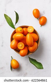 Flat lay kumquats in a bowl on a marble background. Top view