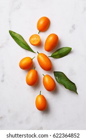 Flat lay of kumquats on a marble background. Top view