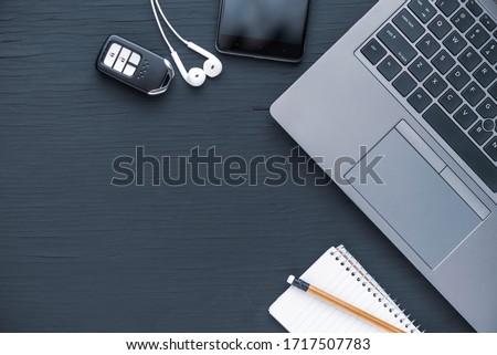 Flat lay of laptop computer notebook, smarthphone, earphone, pencel and car key with copy space for text
