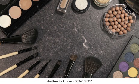 Flat lay of make up and beauty cosmetic products over black marble background
