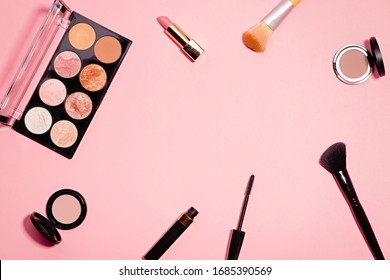 Flat Lay With Make Up Products In Minimal Style On Pink Desk. Frame With Black Mascara, Lipstick, Eyeshadow Palette, Different Make Up Brushes. Top View, Copy Space.