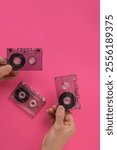 Flat lay of male music lover showing collection of tape cassettes with retro songs. Nostalgic audio cassette in hand on a flat background, perfect for retro-themed designs and projects