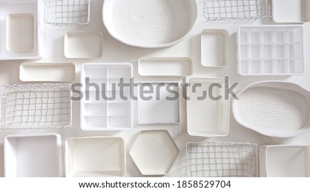 Flat lay of Marie Kondo's white storage boxes, containers and baskets with different sizes and shapes for tidying up wardrobe. KonMari method organizer boxes set. Closet organizing concept.