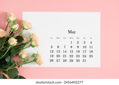 Flat lay of May 2024 paper desk calendar, top view. Pink pale cream rose flowers on pastel pink background. - Powered by Shutterstock