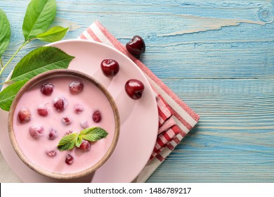 Flat lay of meglevesh, hungarian cold cherry soup, served in wooden bowl 